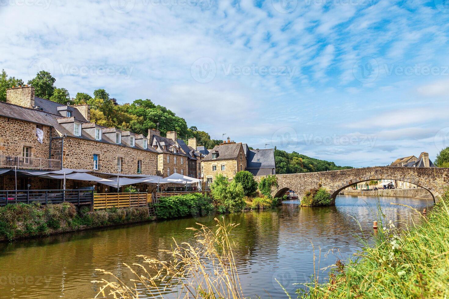 panoramic view of old stone bridge and historical medieval houses reflecting in La Rance river in Dinan town port photo