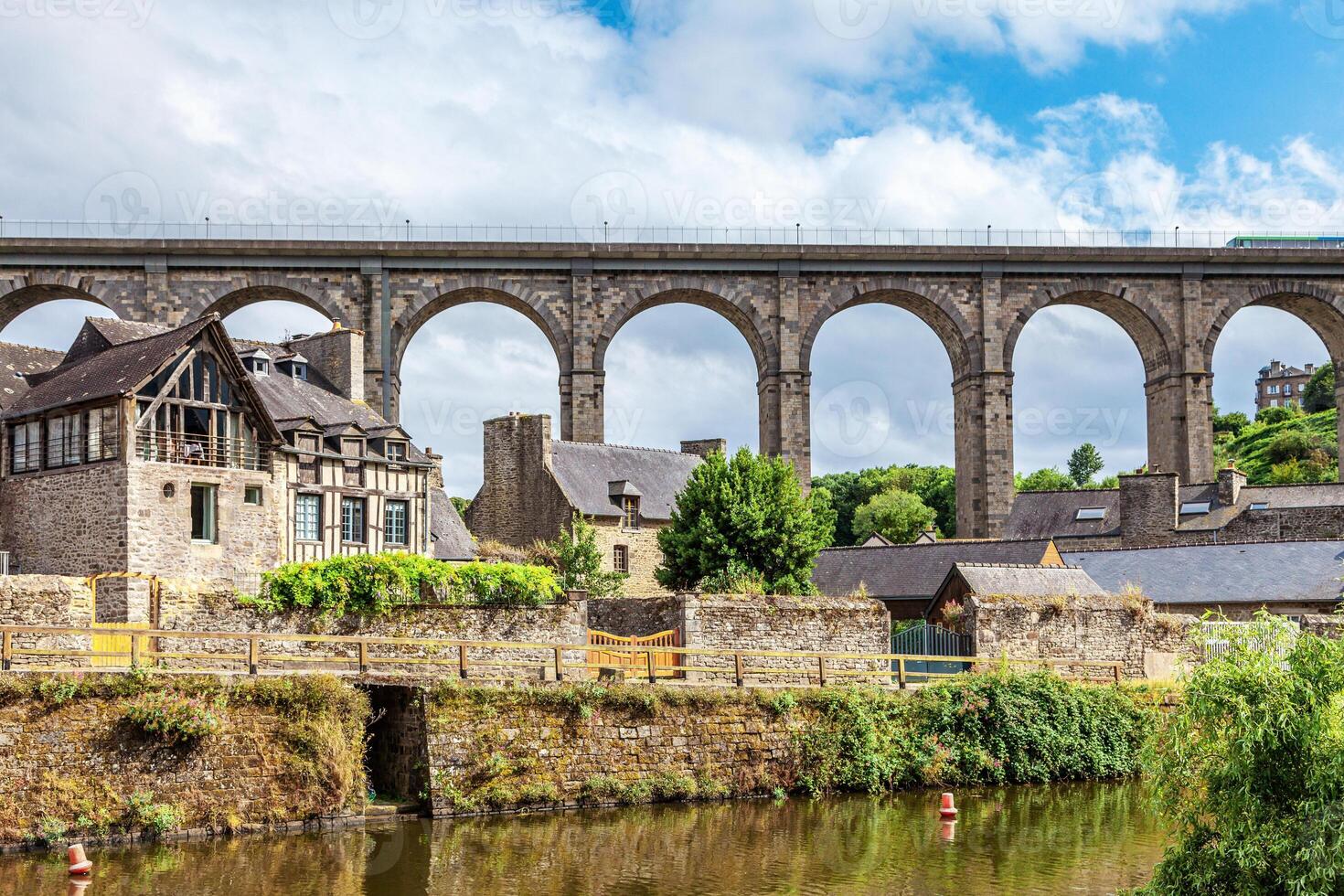 panoramic view of old stone bridge and historical medieval houses reflecting in La Rance river in Dinan town port photo