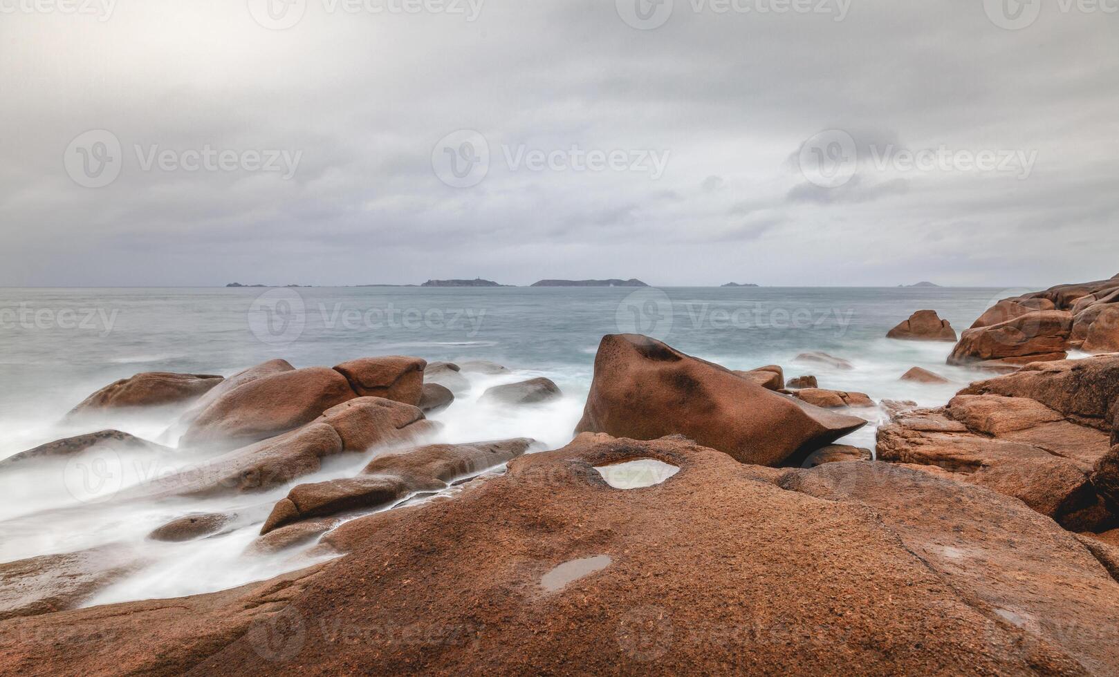 panoramic view of the waves breaking among the giant pink boulders in Brittany photo