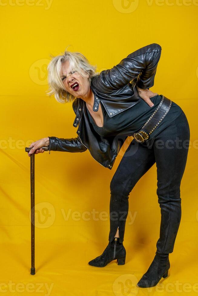 Funny portrait of mature woman. Beautiful lady have fun as a rock star dressed in leather photo
