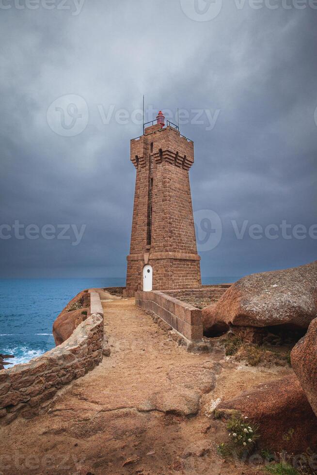 panoramic view of the famous Ploumanach lighthouse among the giant pink boulders in Brittany photo