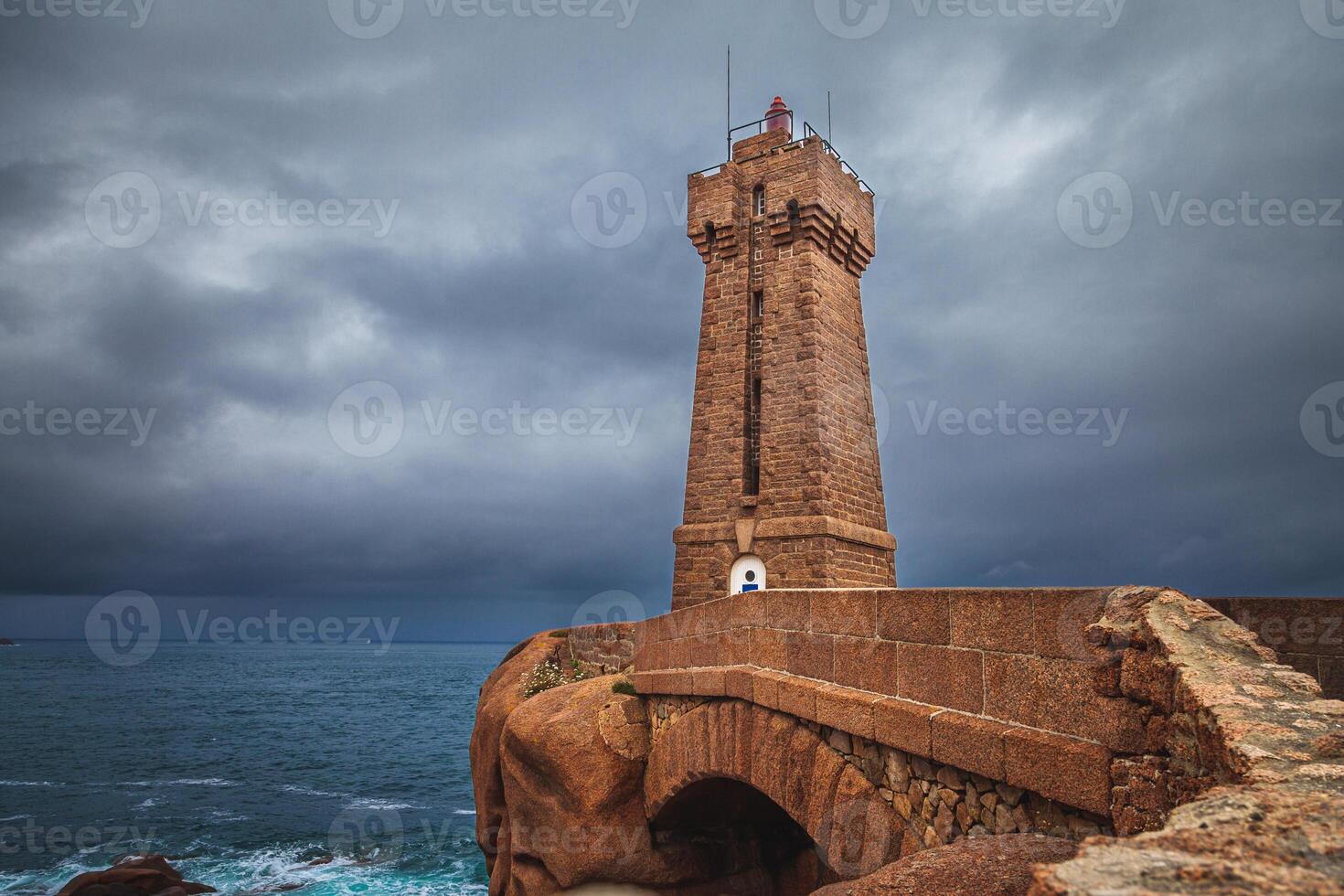 panoramic view of the famous Ploumanach lighthouse among the giant pink boulders in Brittany photo