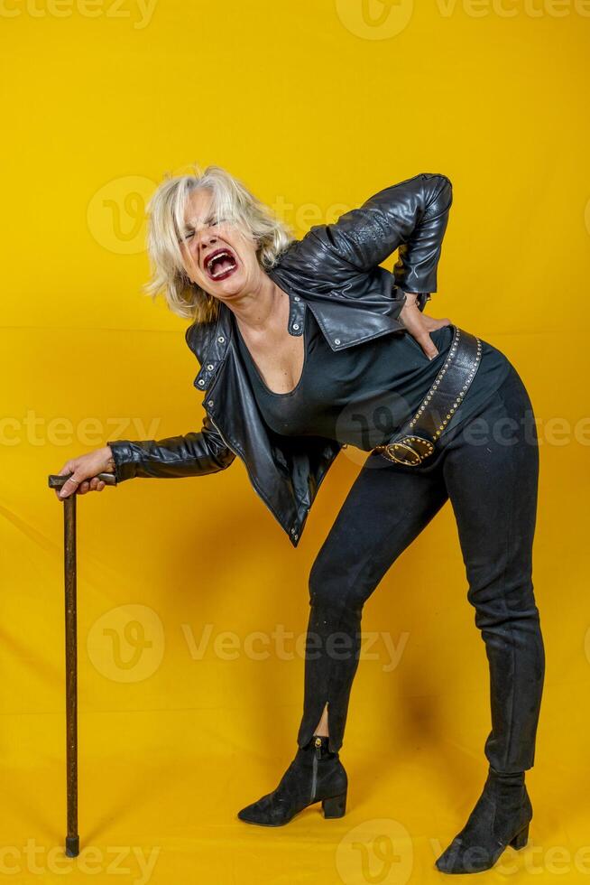 Funny portrait of mature woman. Beautiful lady have fun as a rock star dressed in leather photo