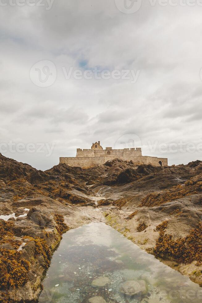 landscape of a medieval fortress on the French coast seen at low tide photo