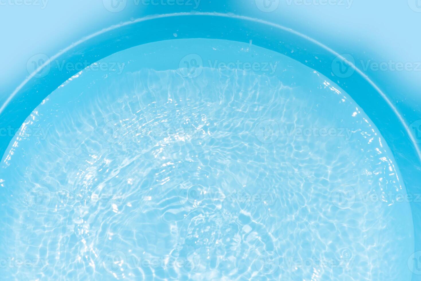 Bluewater waves on the surface ripples blurred. Defocus blurred transparent blue colored clear calm water surface texture with splash and bubbles. Water waves with shining pattern texture background. photo