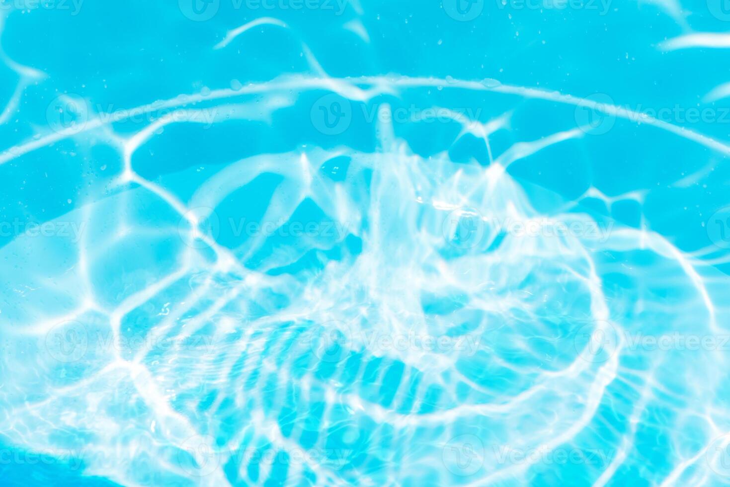 Bluewater waves on the surface ripples blurred. Defocus blurred transparent blue colored clear calm water surface texture with splash and bubbles. Water waves with shining pattern texture background. photo