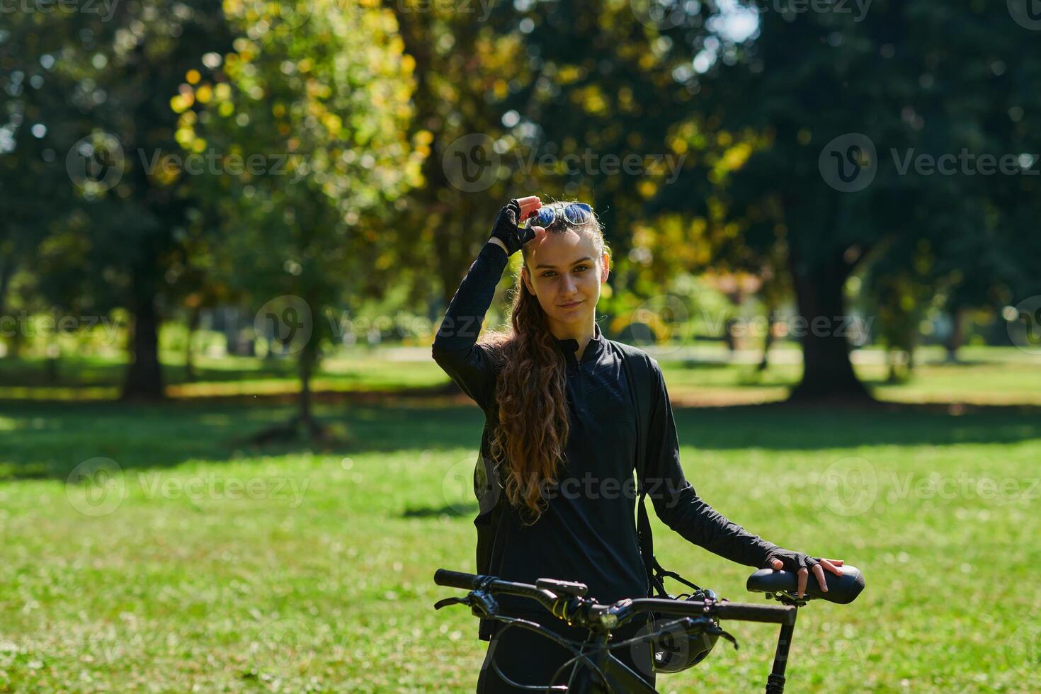 In the radiant embrace of a sunny day, a joyous girl, adorned in professional cycling gear, finds pure bliss and vitality as she cruises through the park on her bicycle, her infectious laughter photo
