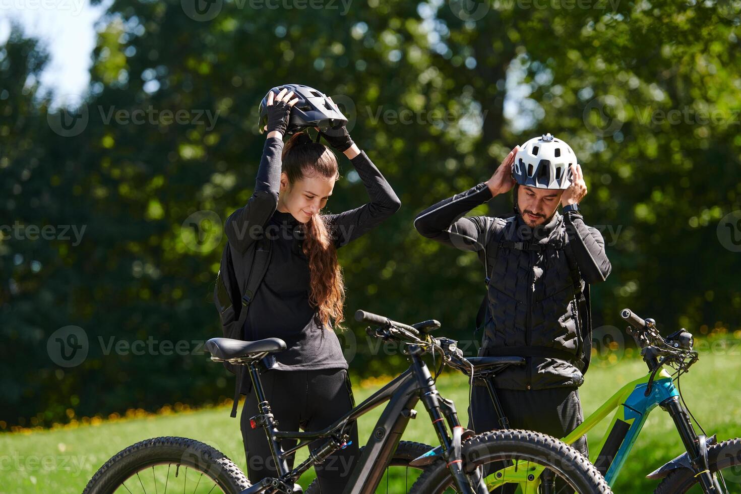 A sweet couple, equipped with bicycles and engrossed in coordinating their journey, checks their GPS mobile and watches while planning scenic routes in the park, seamlessly blending technology and photo