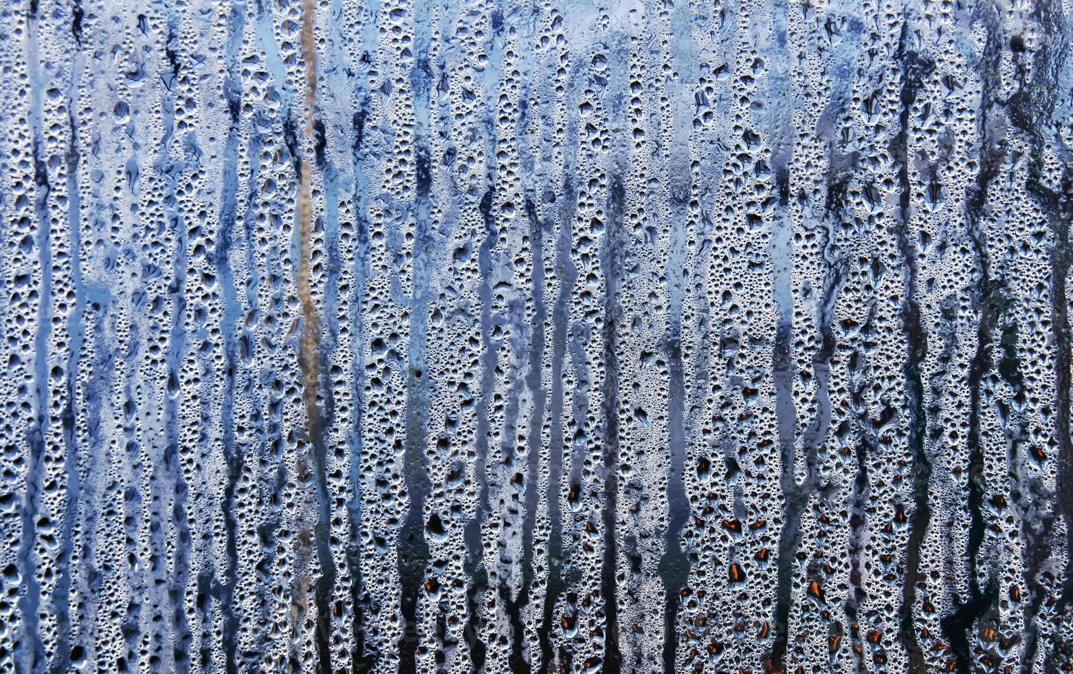Texture of rain drops on a glass wet transparent surface. photo