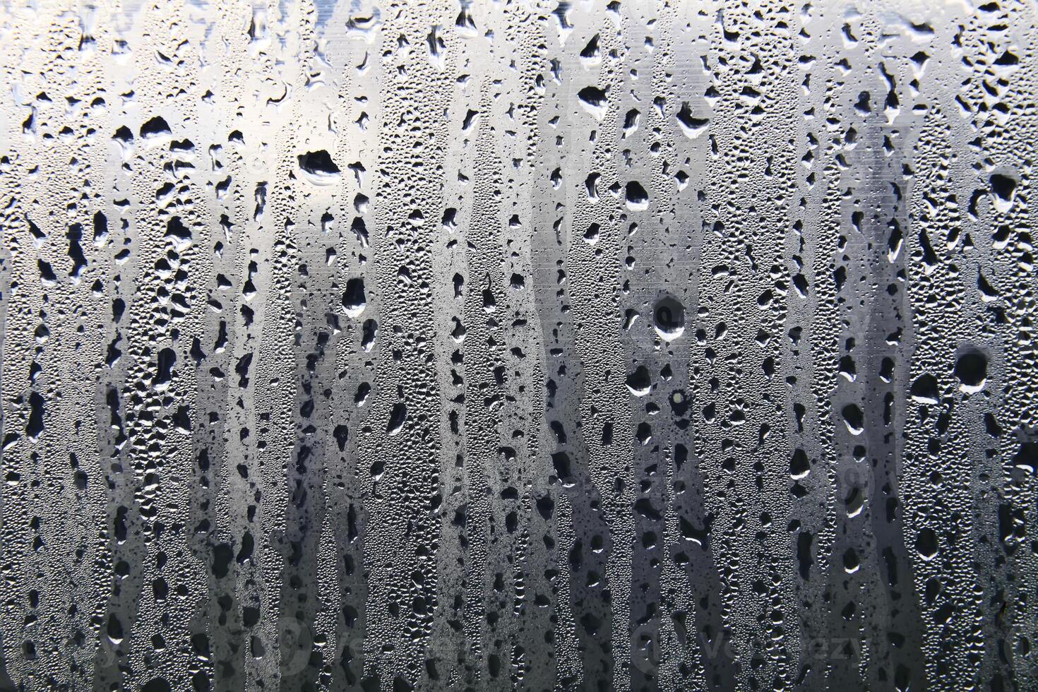 Texture of rain drops on a glass wet transparent surface. photo