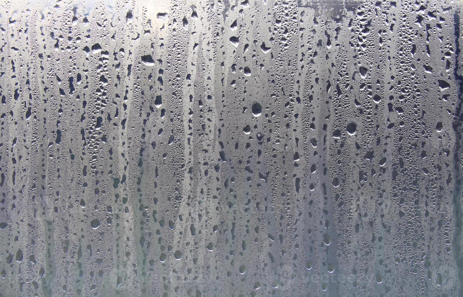 Texture of rain drops on a glass wet transparent surface. photo