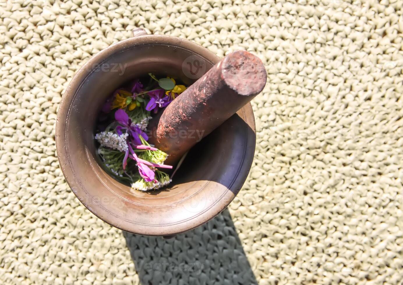 Medicinal herbs and flowers in a cooper mortar. photo