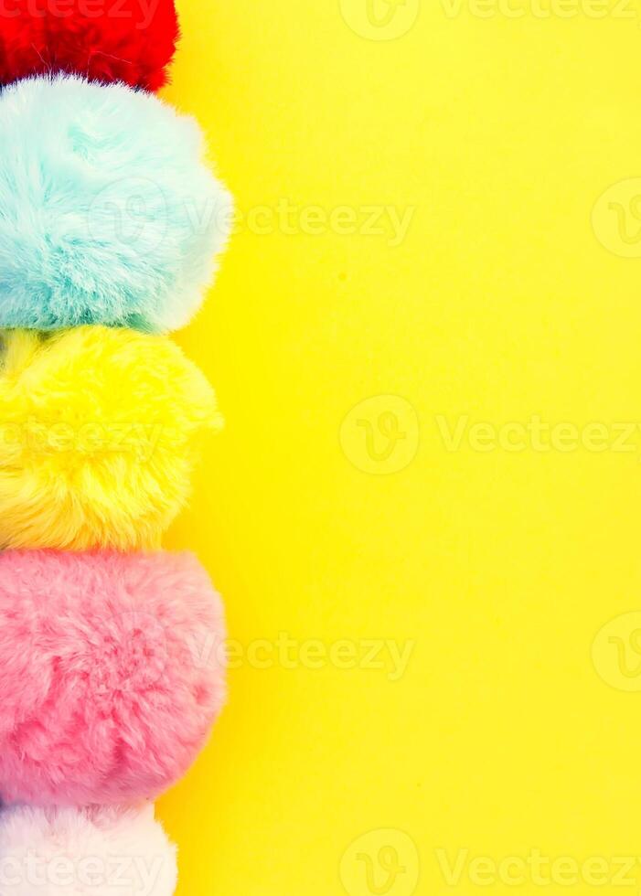 Colorful fluffy pompons on bright background. Fashion decoration festive template. photo