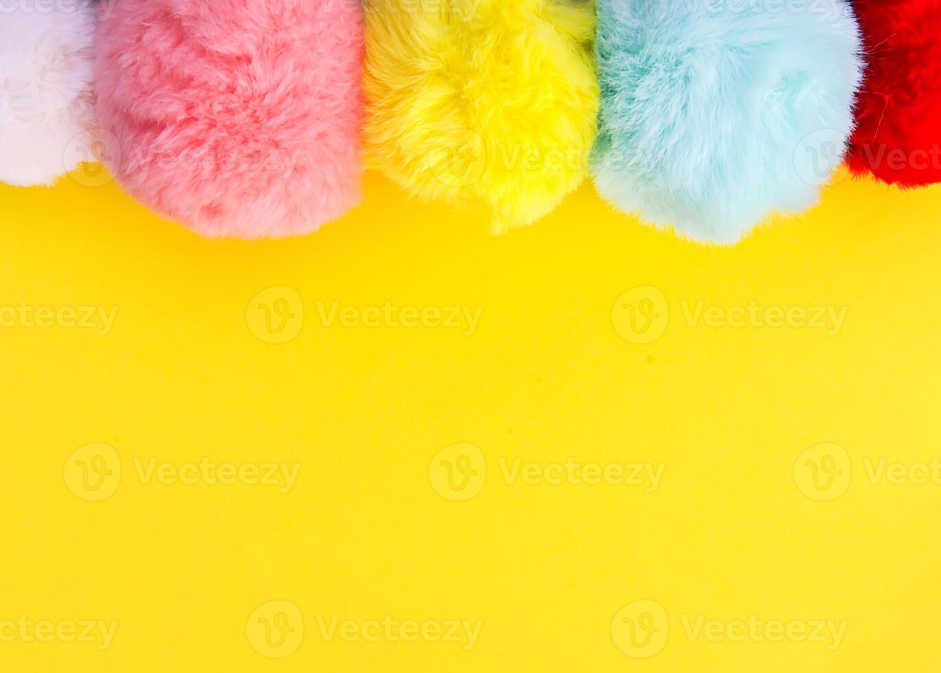 Colorful fluffy pompons on bright background. Fashion decoration festive template. photo