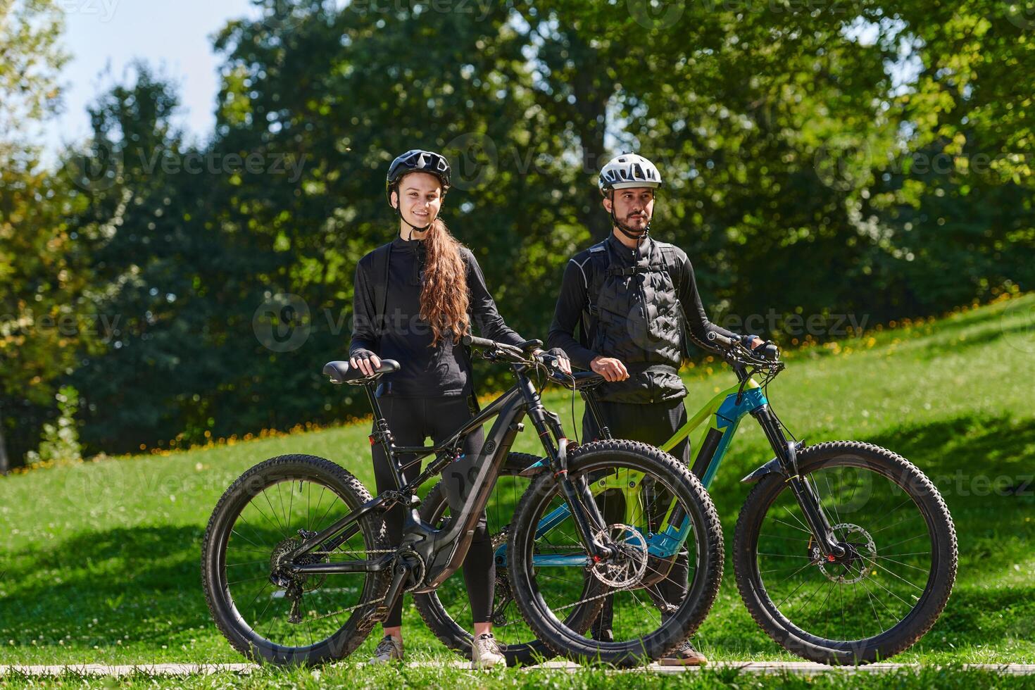 A sweet couple, equipped with bicycles and engrossed in coordinating their journey, checks their GPS mobile and watches while planning scenic routes in the park, seamlessly blending technology and photo