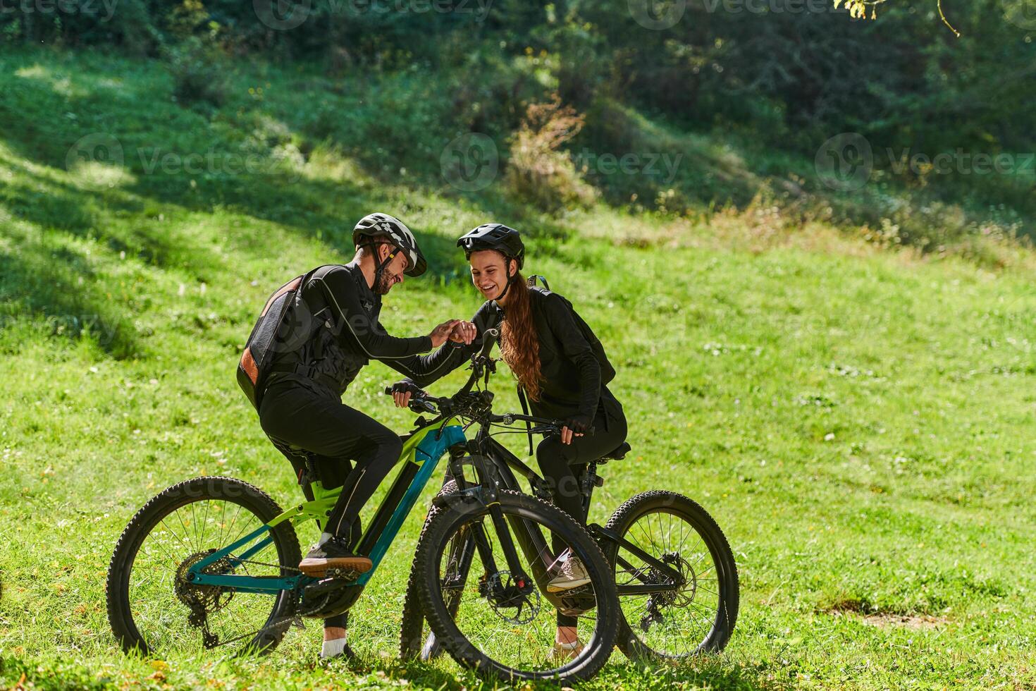 A sweet couple, equipped with bicycles and engrossed in coordinating their journey, checks their GPS mobile and watches while planning scenic routes in the park, seamlessly blending technology and photo