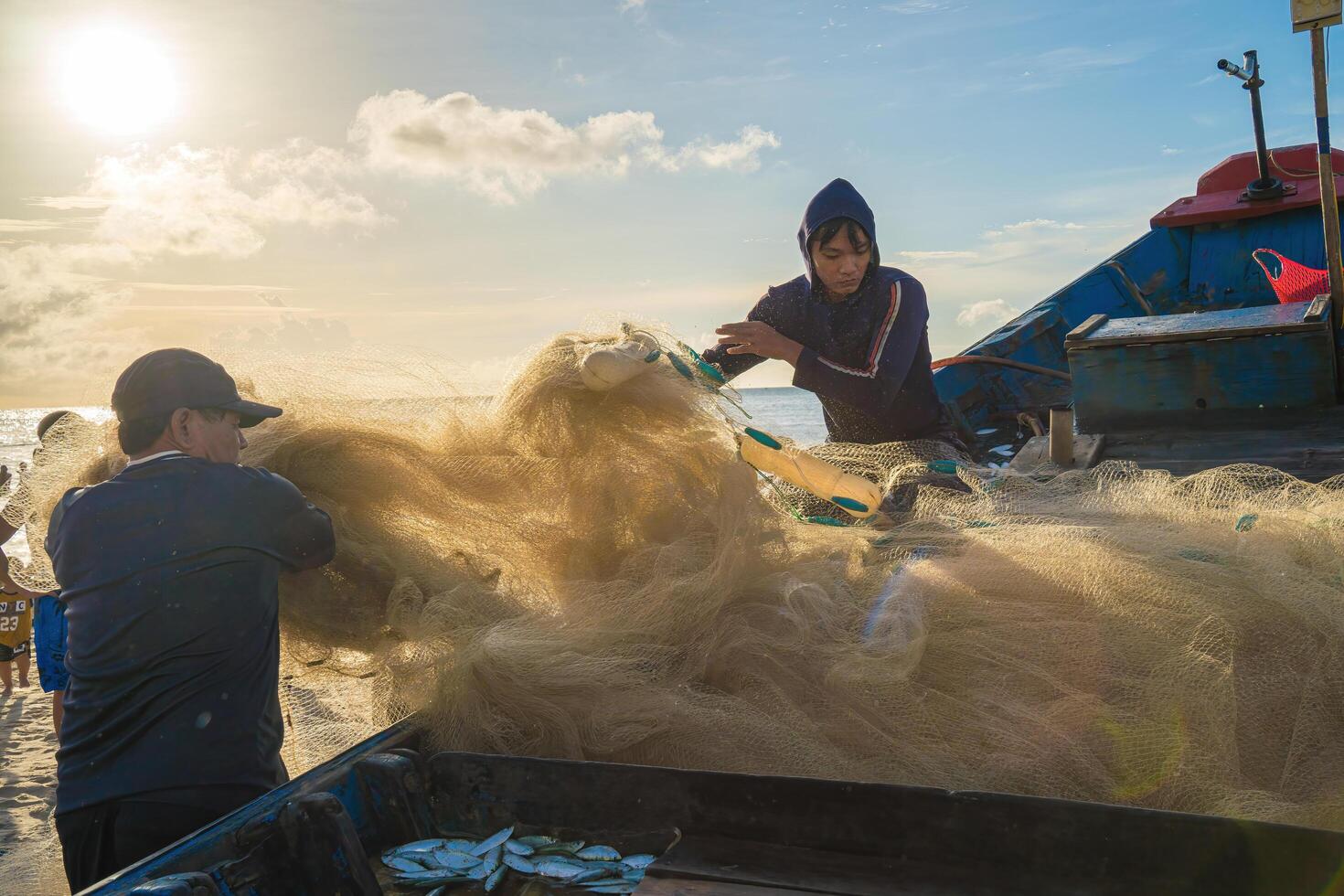 Vung Tau, VIETNAM - AUG 20 2022 Fisherman casting his net at the sunrise or sunset. Traditional fishermen prepare the fishing net. Fishermen on beach at the Fishing. photo