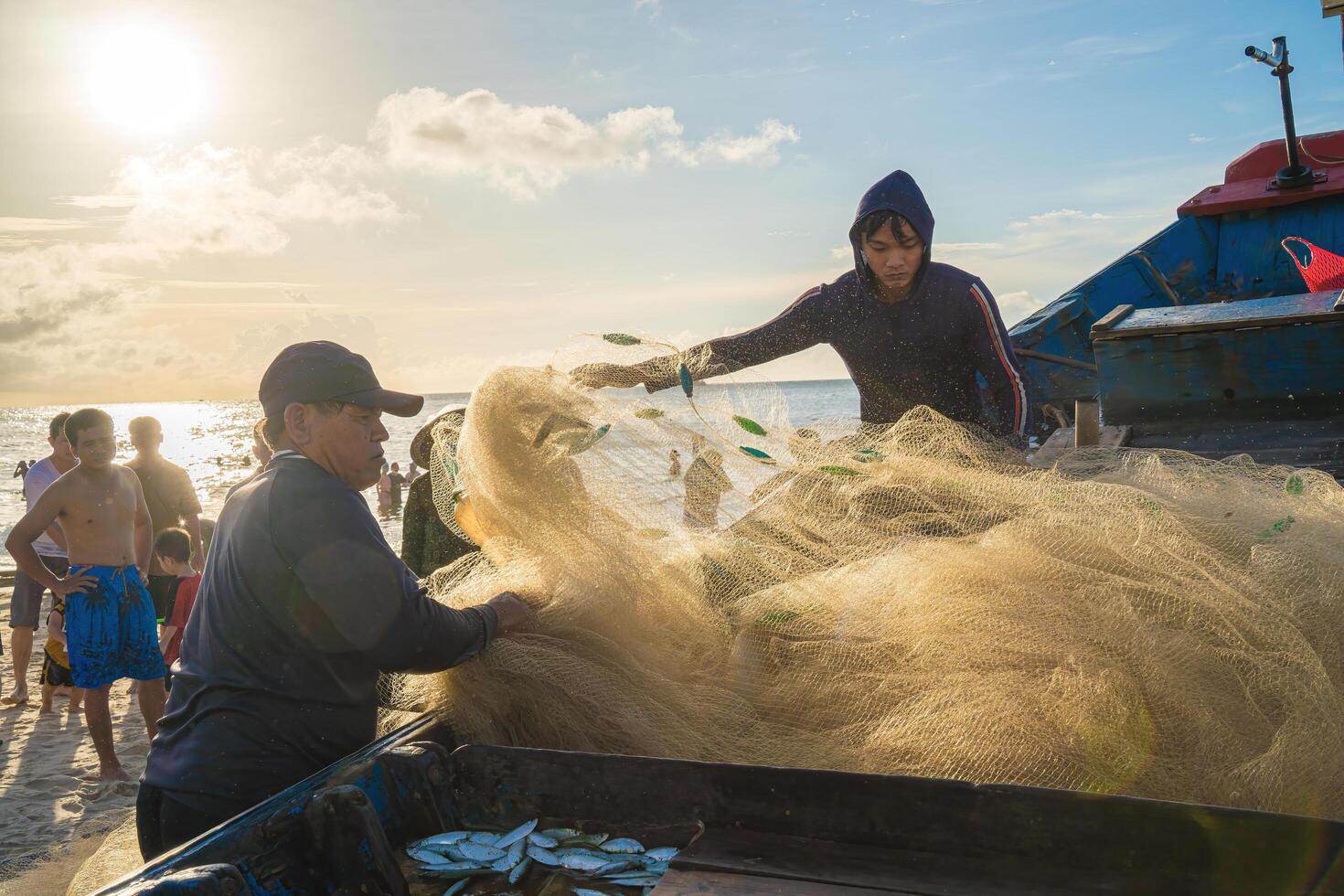Vung Tau, VIETNAM - AUG 20 2022 Fisherman casting his net at the sunrise or sunset. Traditional fishermen prepare the fishing net. Fishermen on beach at the Fishing. photo