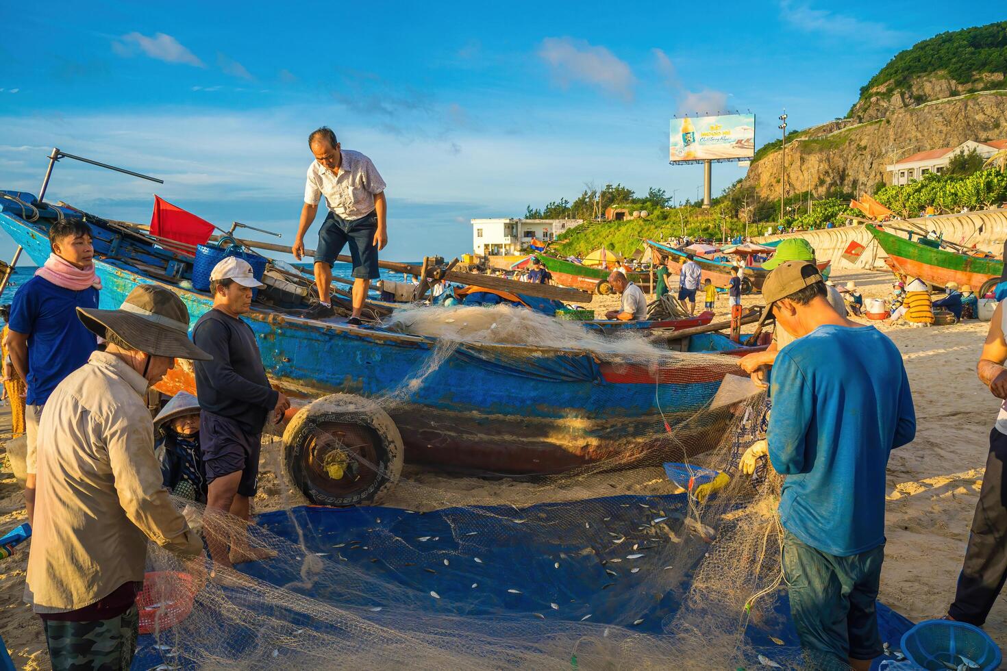Vung Tau, VIETNAM - AUG 20 2022 Fisherman casting his net at the sunrise or sunset. Traditional fishermen prepare the fishing net. Fishermen on beach at the Fishing. photo