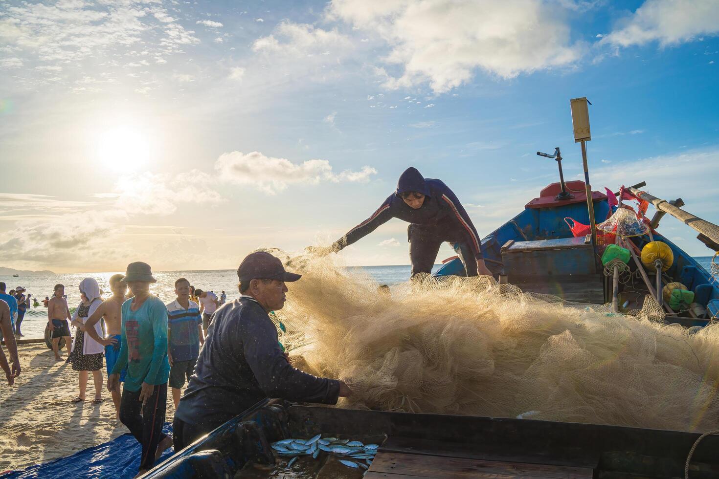 Vung Tau, VIETNAM - AUG 20 2022 Fisherman casting his net at the sunrise or sunset. Traditional fishermen prepare the fishing net. Fishermen on beach at the Fishing. photo