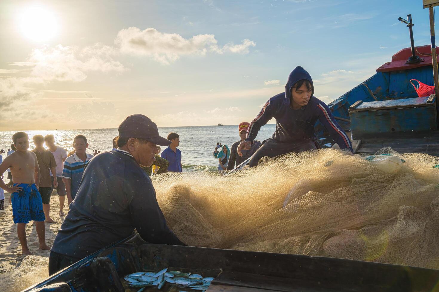 Vung Tau, VIETNAM - AUG 20 2022 Fisherman casting his net at the sunrise or sunset. Traditional fishermen prepare the fishing net. Fishermen on beach at the Fishing. photo