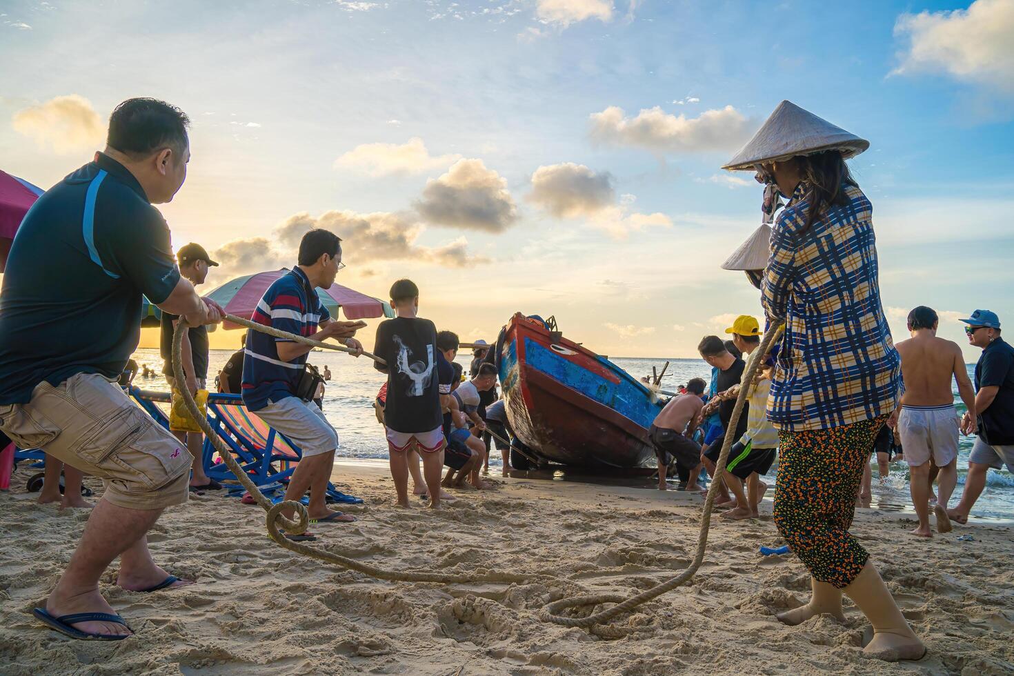 Vung Tau, VIETNAM - AUG 20 2022 Fisherman casting his net at the sunrise or sunset. Traditional fishermen prepare the fishing net. Fishermen on beach at the Fishing. photo