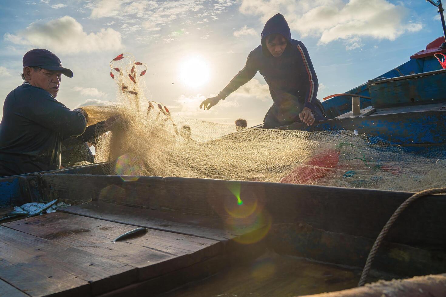 Vung Tau, VIETNAM - AUG 20 2022 Fisherman casting his net at the sunrise or sunset. Traditional fishermen prepare the fishing net. Fishermen on beach at the Fishing. photo