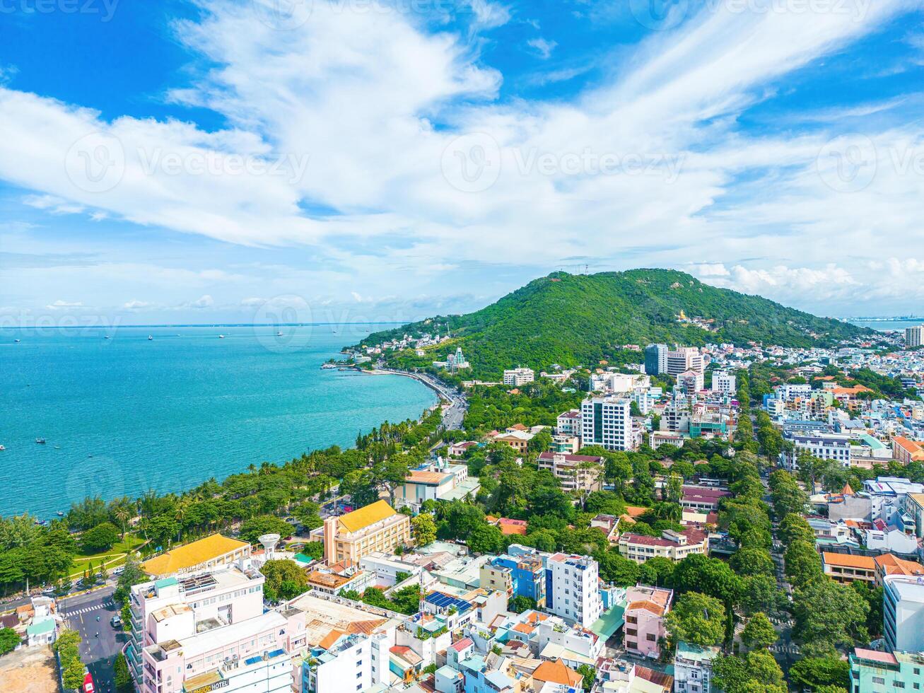 Vung Tau city aerial view with beautiful sunset and so many boats. Panoramic coastal Vung Tau view from above, with waves, coastline, streets, coconut trees and Tao Phung mountain in Vietnam. photo