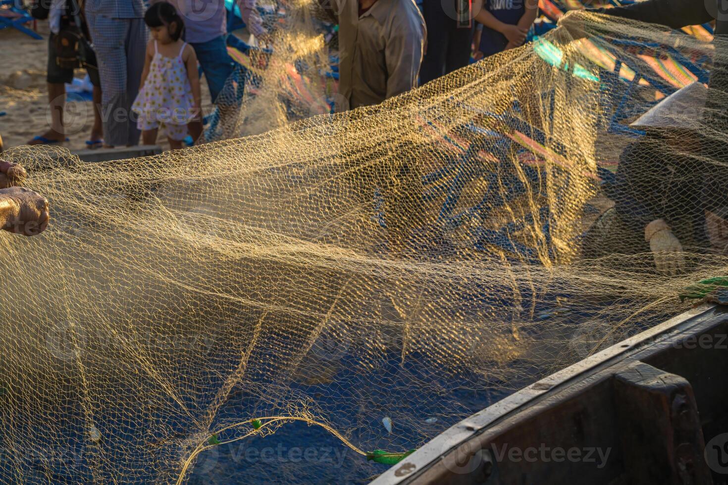 Fisherman casting his net at the sunrise or sunset. Traditional fishermen prepare the fishing net. Fishermen on beach at the Fishing. photo