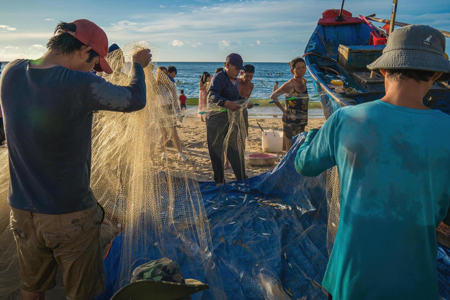 Vung Tau, VIETNAM - AUG 20 2022 Fisherman casting his net at the sunrise or sunset. Traditional fishermen prepare the fishing net. Fishermen on beach at the Fishing. photo