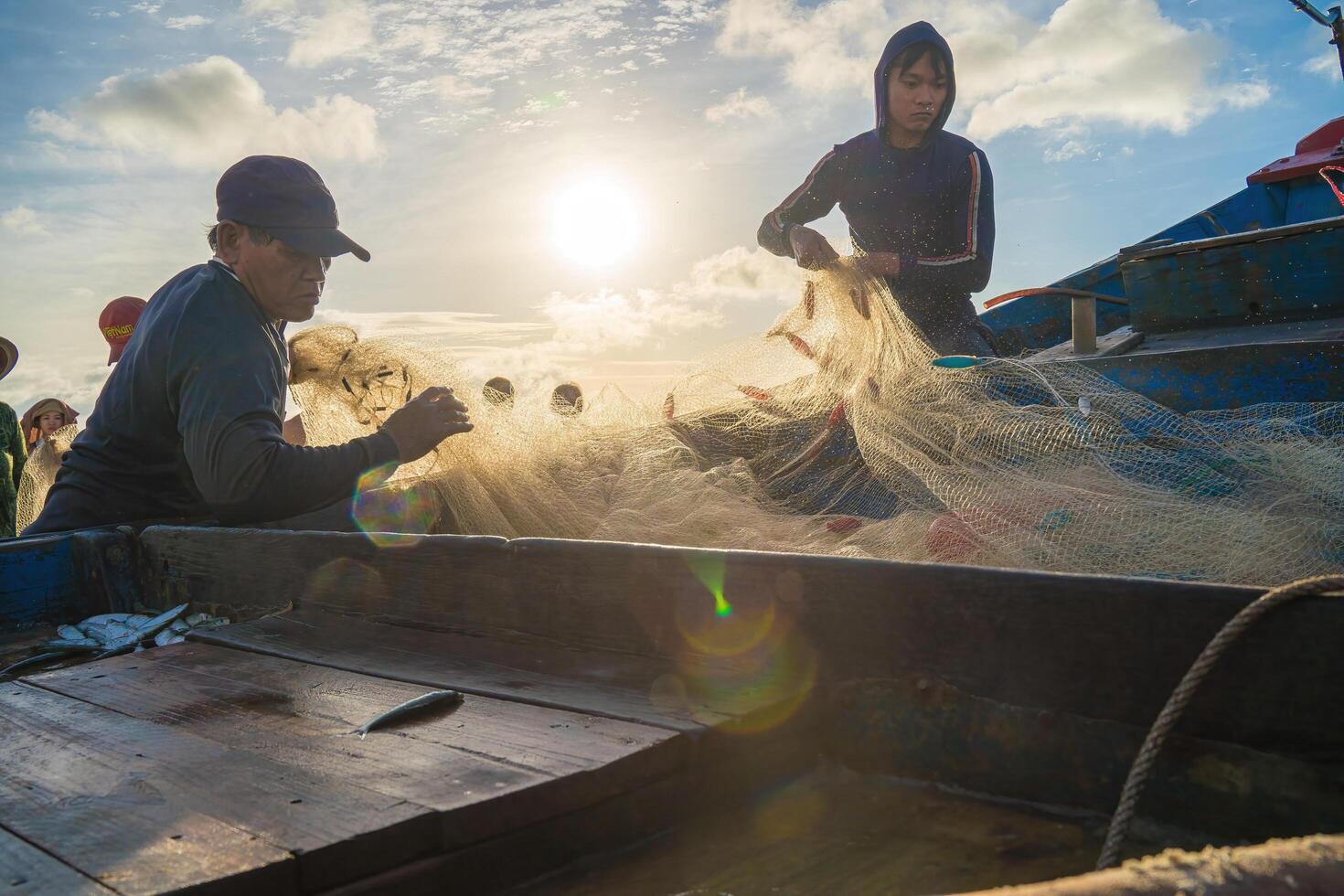 Vung Tau, VIETNAM - AUG 20 2022 Fisherman casting his net at the sunrise or sunset. Traditional fishermen prepare the fishing net. Fishermen on beach at the Fishing. photo