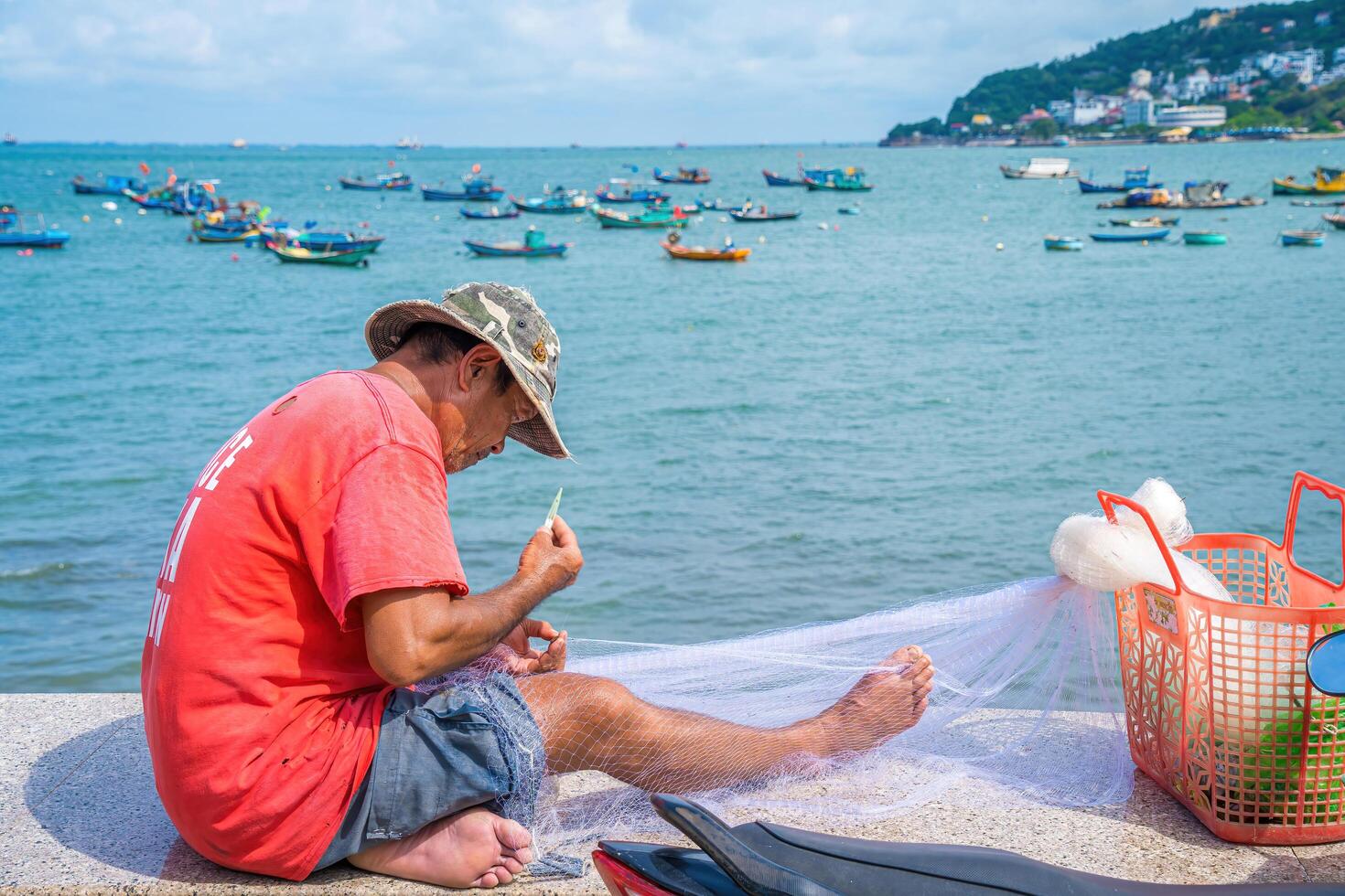 Vung Tau, VIETNAM - AUG 20 2022 Fisherman casting his net at the sunrise or sunset. Traditional fishermen prepare the fishing net. Fishermen on beach at the Fishing. photo