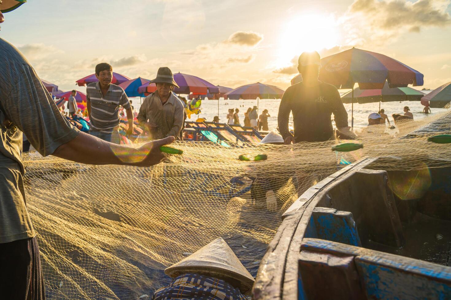Vung Tau, VIETNAM - AUG 20 2022 Fisherman casting his net at the sunrise or sunset. Traditional fishermen prepare the fishing net. Fishermen on beach at the Fishing. photo