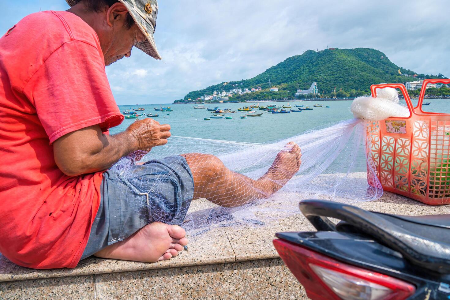 Vung Tau, VIETNAM - AUG 20 2022 Fisherman casting his net at the sunrise or sunset. Traditional fishermen prepare the fishing net. Fishermen on beach at the Fishing. photo