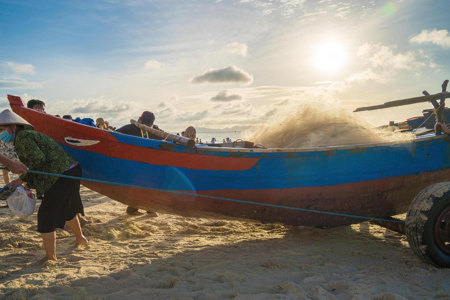 Vung Tau, VIETNAM - AUG 20 2022 Fisherman casting his net at the sunrise or sunset. Traditional fishermen prepare the fishing net. Fishermen on beach at the Fishing. photo