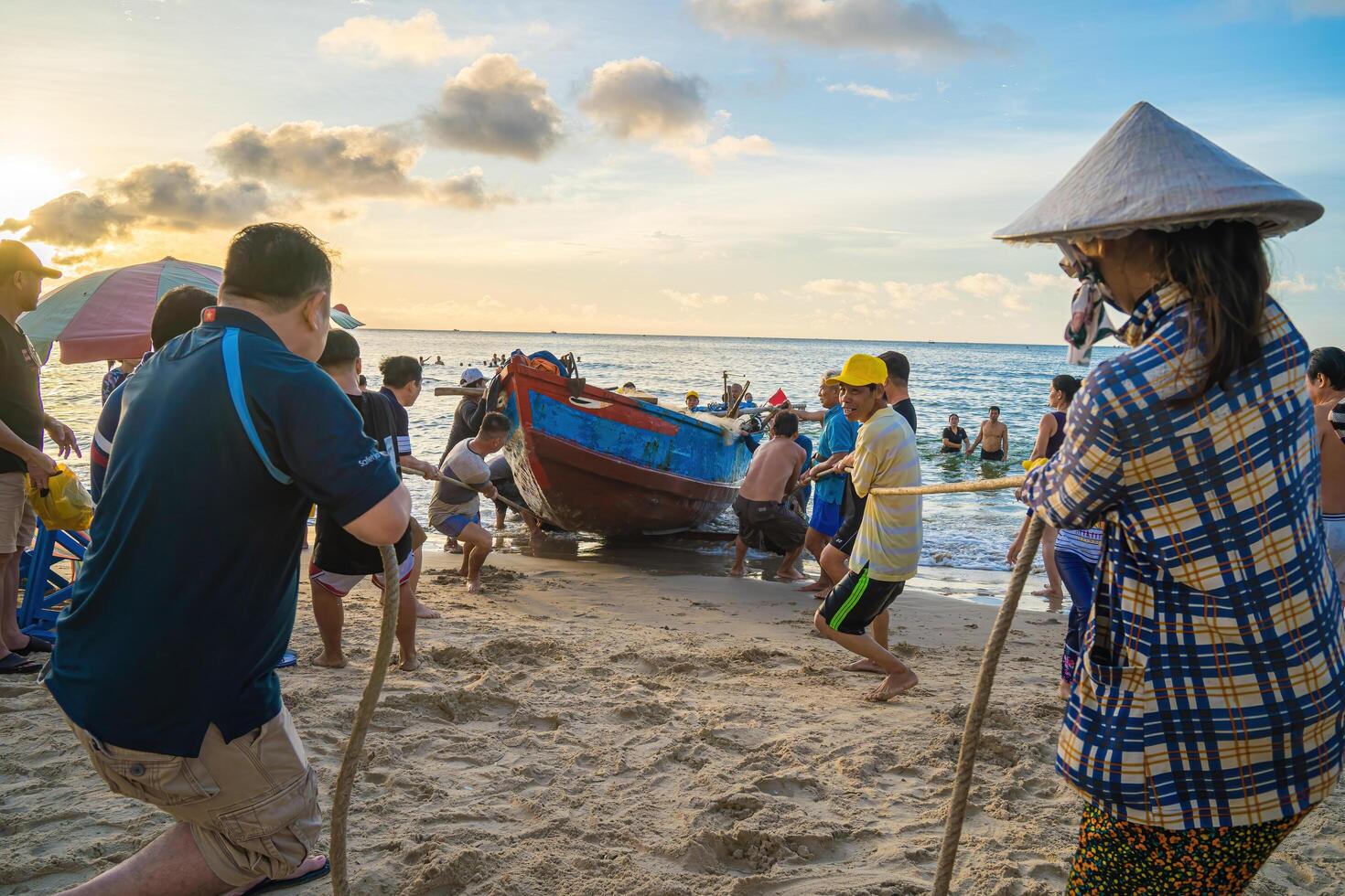 Vung Tau, VIETNAM - AUG 20 2022 Fisherman casting his net at the sunrise or sunset. Traditional fishermen prepare the fishing net. Fishermen on beach at the Fishing. photo