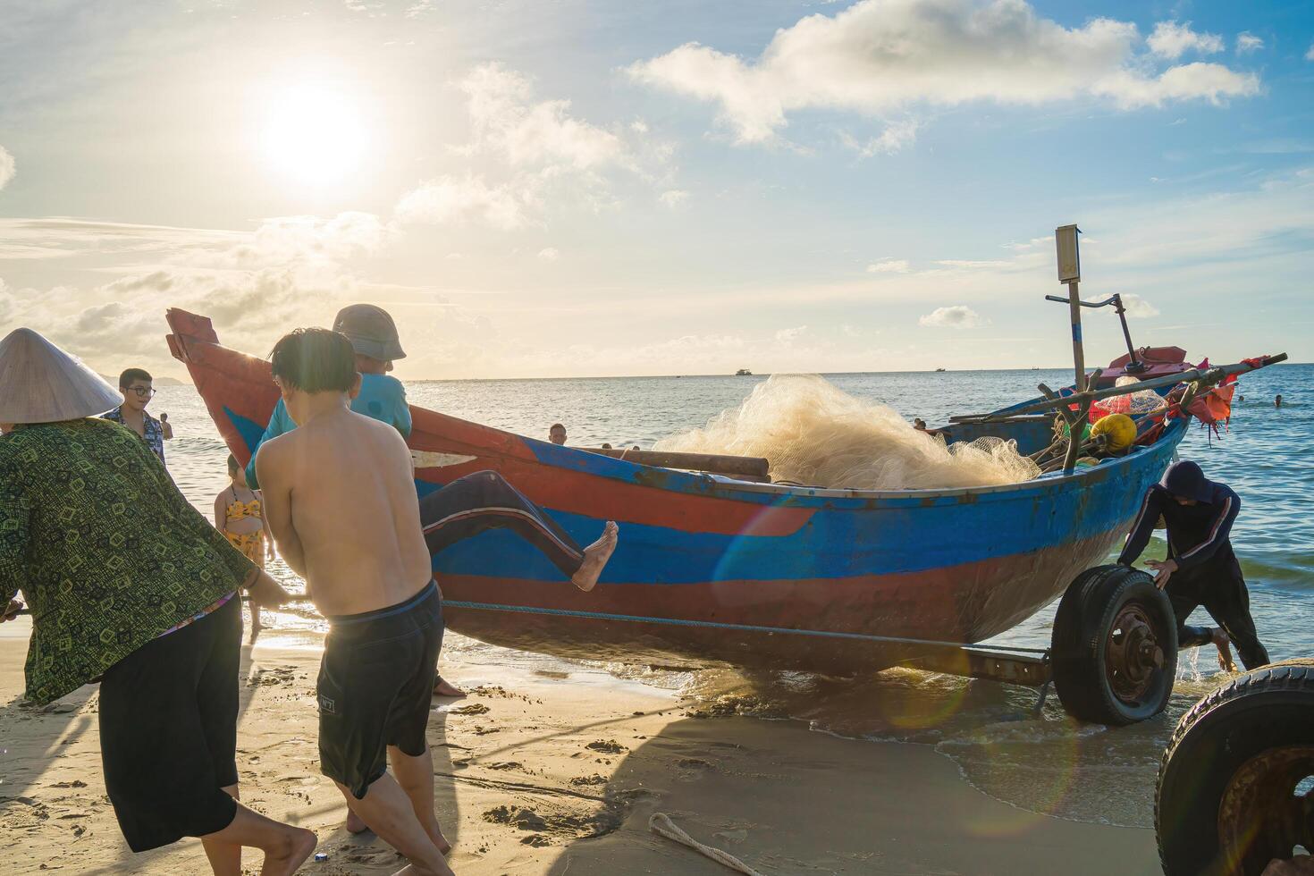 Vung Tau, VIETNAM - AUG 20 2022 Fisherman casting his net at the sunrise or sunset. Traditional fishermen prepare the fishing net. Fishermen on beach at the Fishing. photo