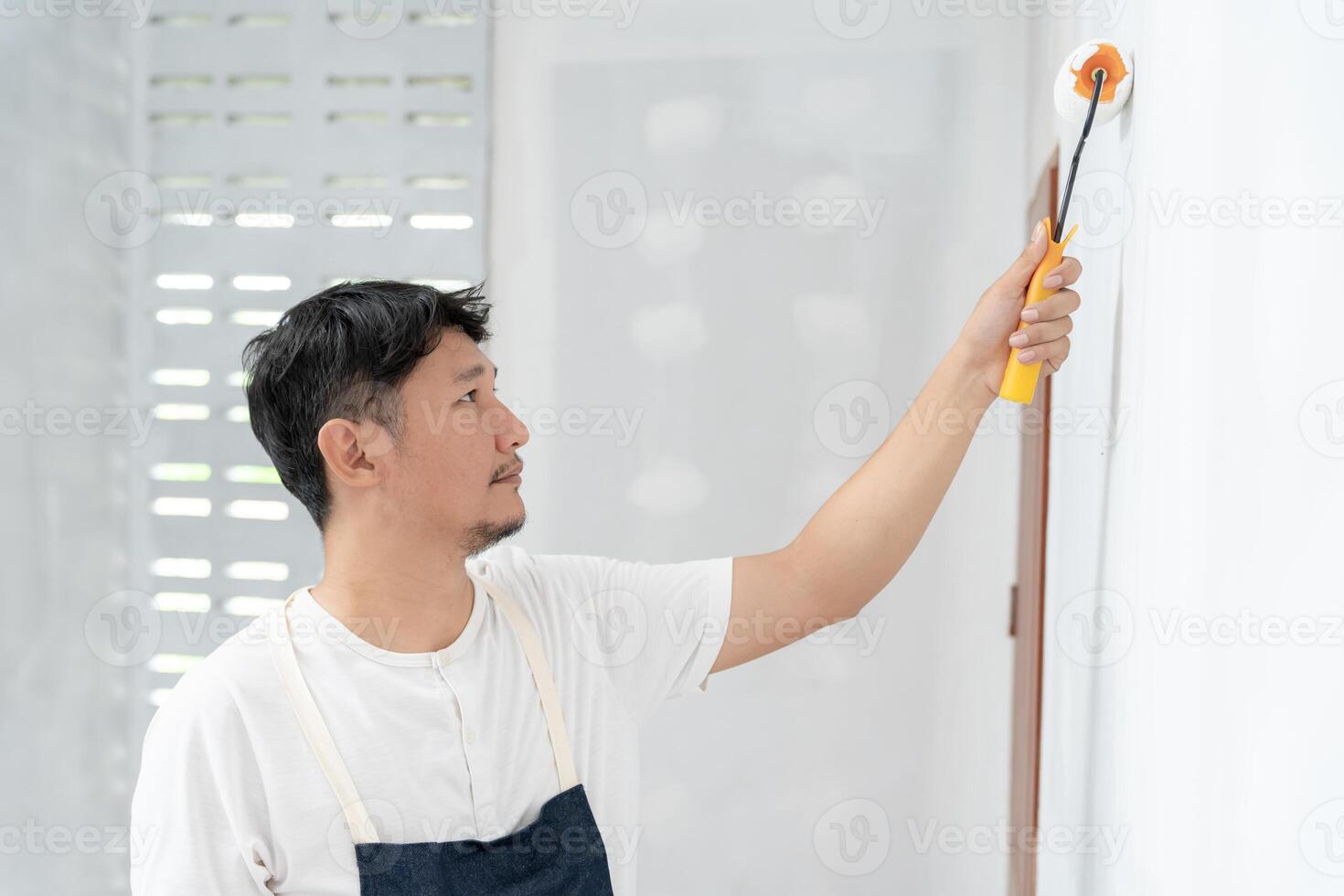 painter man, brush in hand for products to restore and paint the wall, indoor the building site of a house, wall during painting, renovation, painting, contractor, Architect, construction worker photo