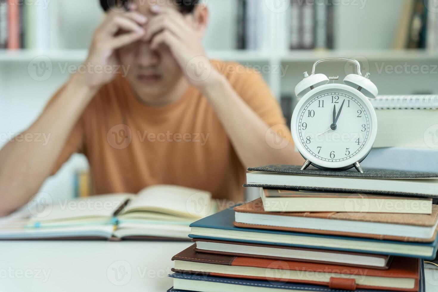 student man have anxiety because of exams, male prepare for test and learning lessons in the library. stress, despair, haste, misunderstanding reading, discouraged, expectation, knowledge, tired photo