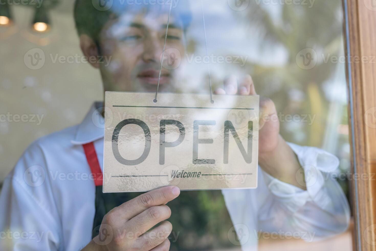 Business man owner show sign open on the first day of business. guarantees safety, cleanliness, open the coffee shop. open for New normal. Small business, welcome, restaurant, home made photo
