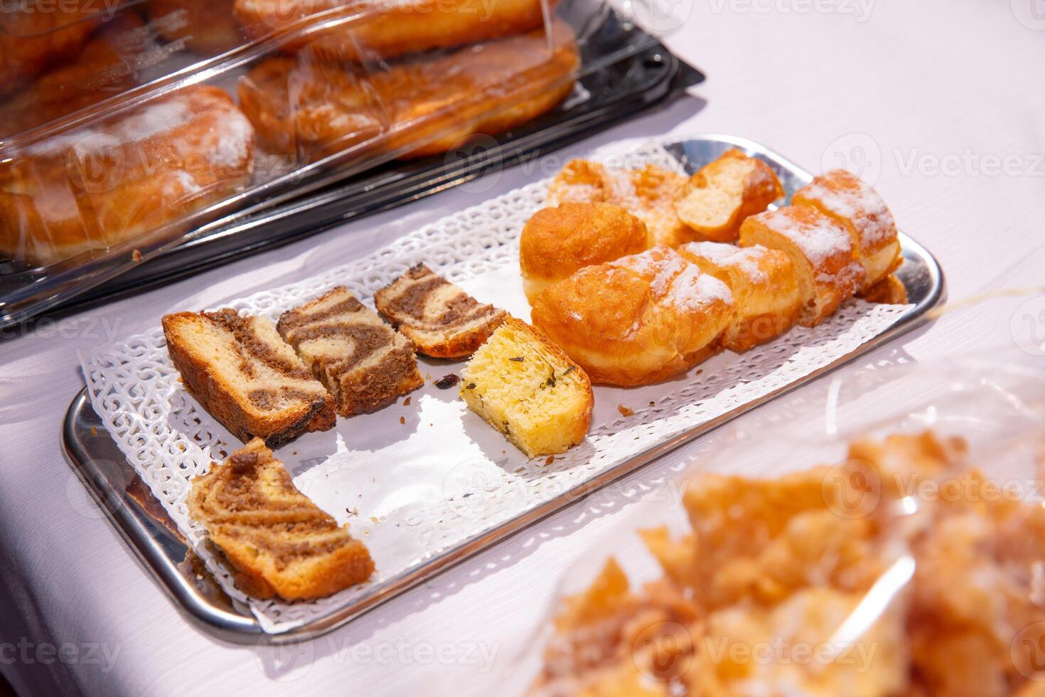 Assorted pastries, cakes on a tray at bakery event, colorful baked goods concept photo
