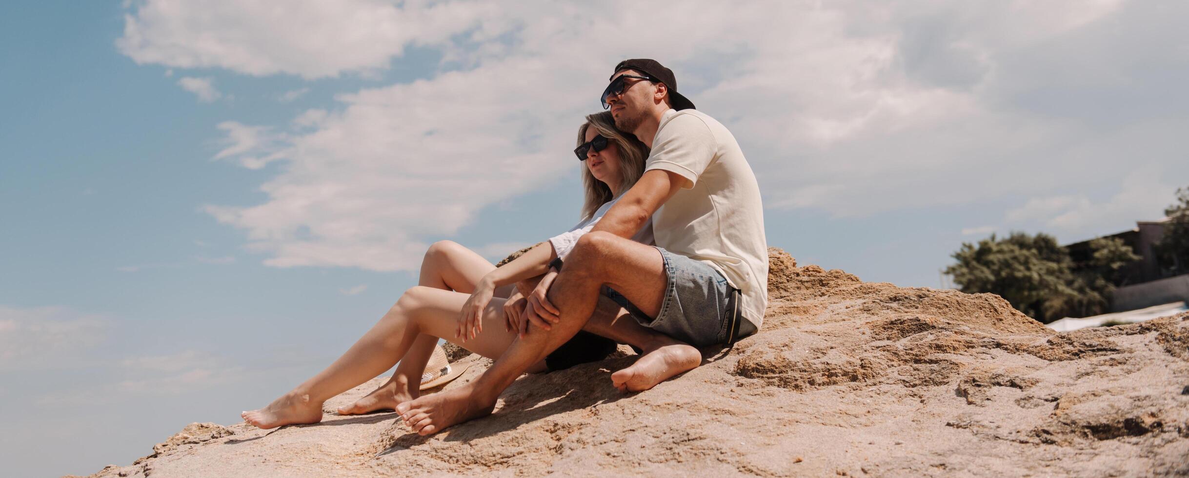 Beautiful romantic couple bonding while enjoying the scenery on the top of rocky mountain together photo