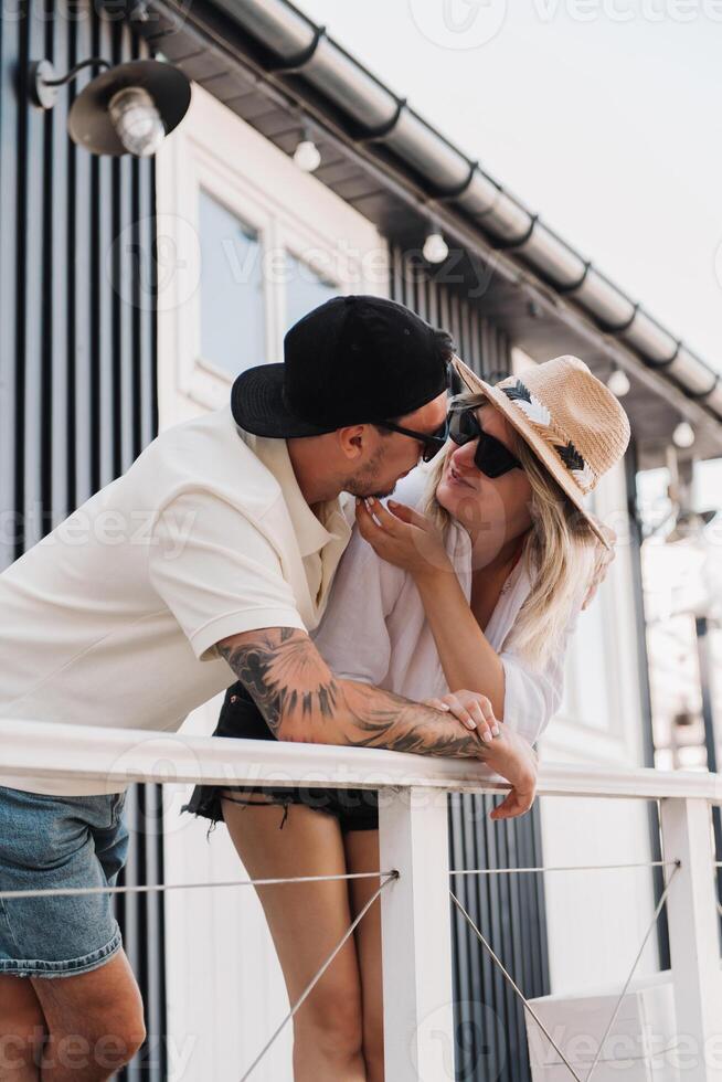 Young romantic couple bonding and smiling while spending summer day on the house terrace together photo