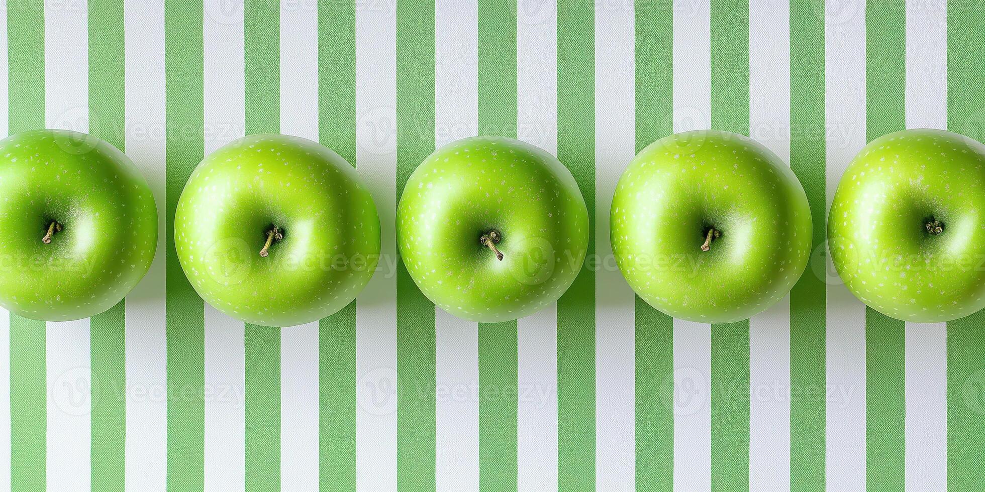 Row of fresh green apples on striped background photo