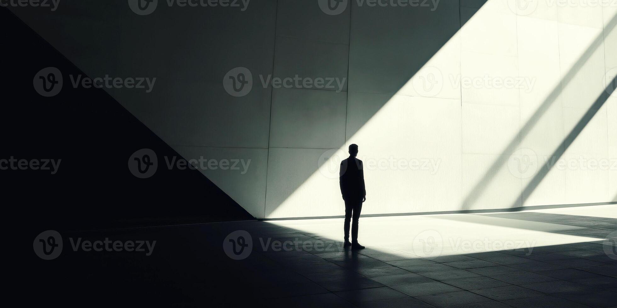 Silhouette of person standing in dramatic light and shadow play in modern architectural space photo
