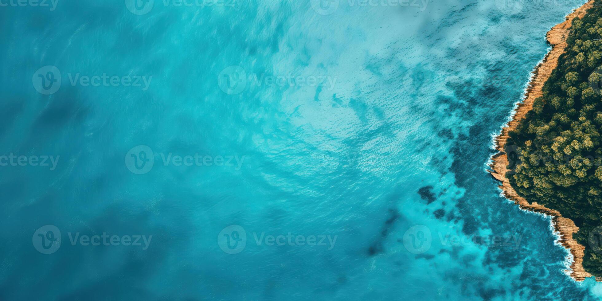 Aerial View of Turquoise Ocean and Rocky Coastline with Lush Green Forest photo