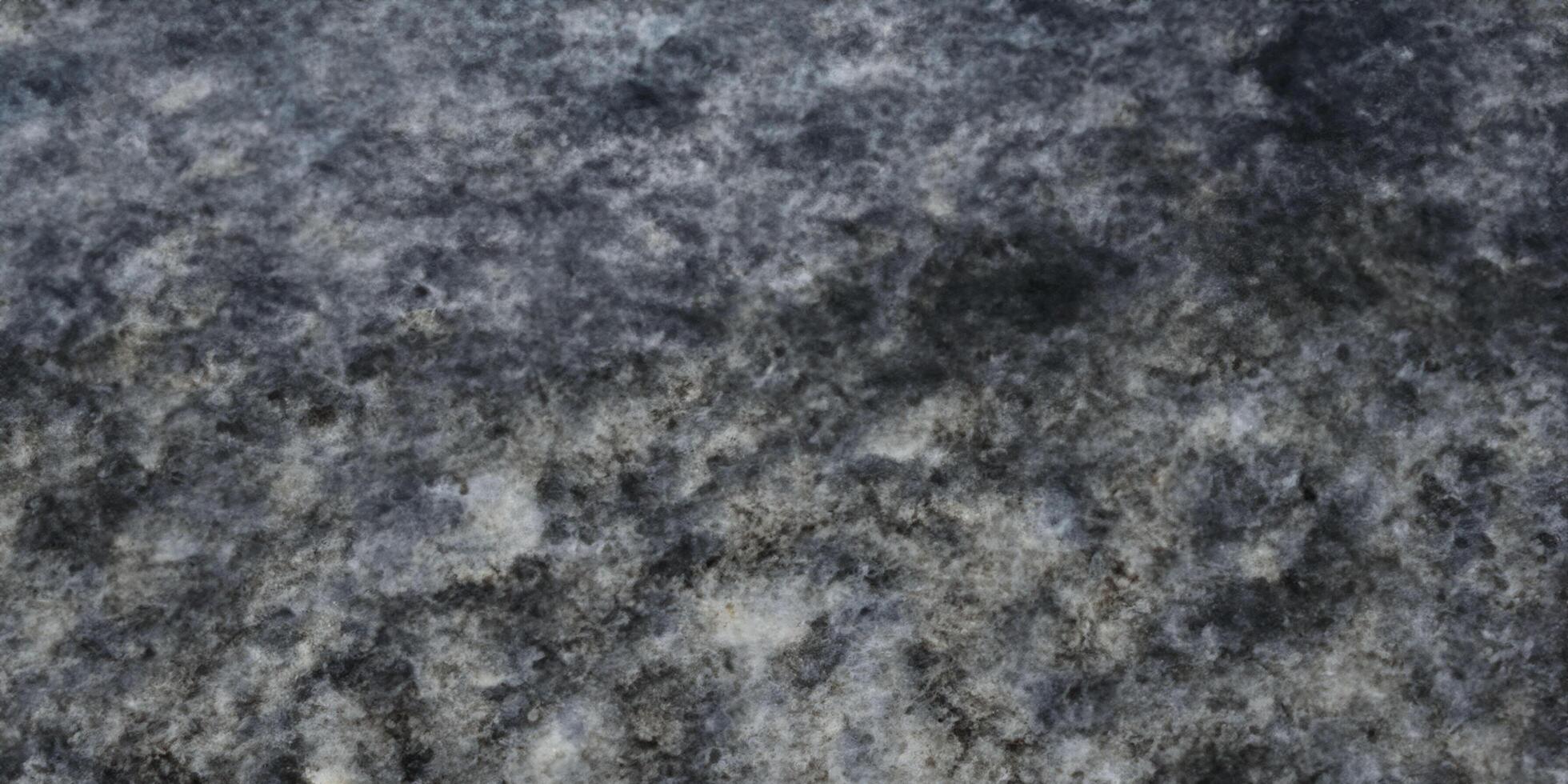 Textured abstract background of gray and black rough stone surface photo