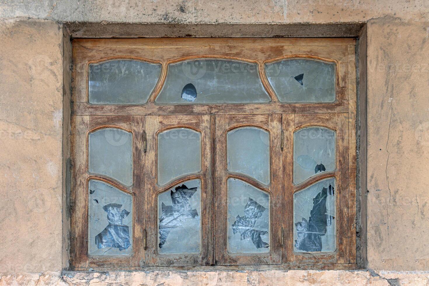 Old wooden window frame in Art Nouveau style with broken glass. photo