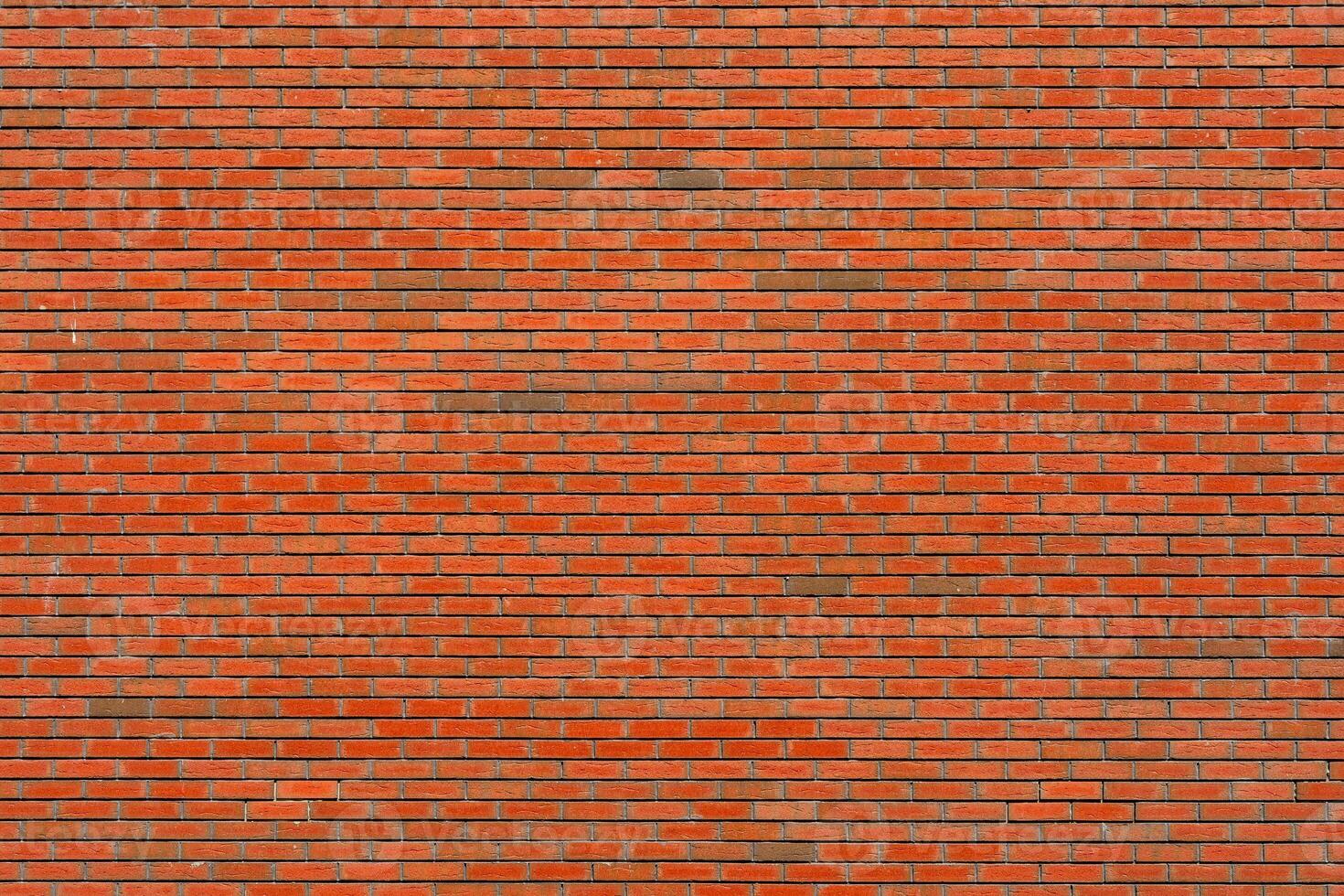 Wall of red brick. Designer interior background. Abstract architectural surface. photo