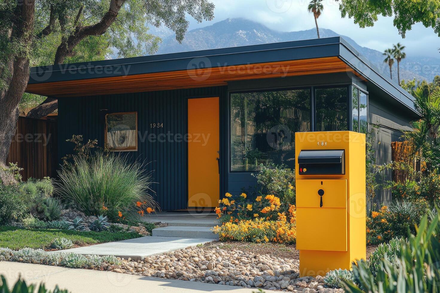 Yellow mailbox standing in front of a modern house with palm trees photo
